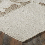 Close-up of a textured beige rug on a wooden floor