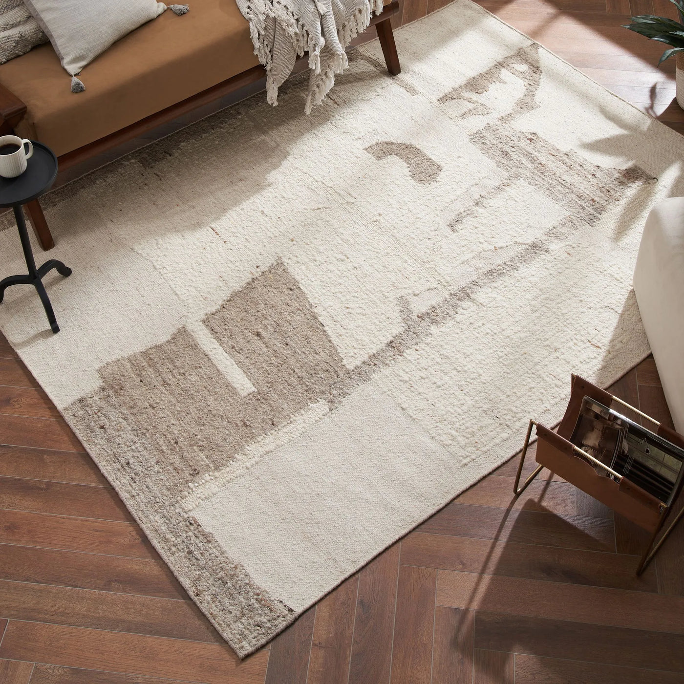 Beige and brown patterned rug on a wooden floor with furniture around