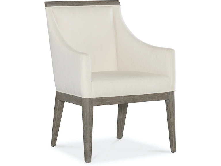A beige upholstered dining chair with armrests and wooden legs, viewed from a front angle.