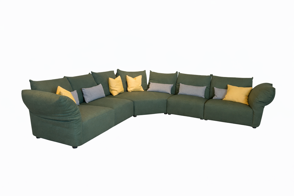 Green sectional sofa with colorful cushions on a white background