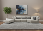 Gray sectional sofa in a living room with abstract art and a plant.