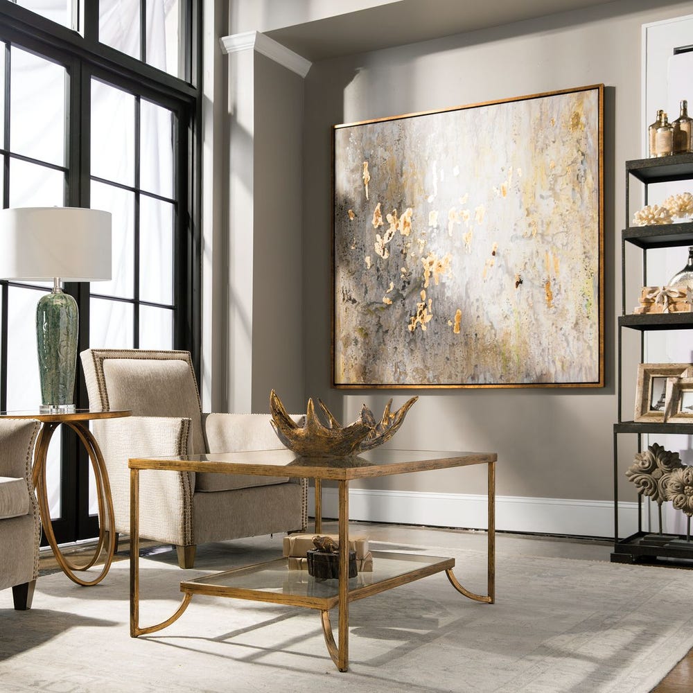 Modern living room with a gold coffee table, armchair, and abstract painting on the wall.