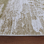 Close-up of a textured green and beige area rug on a wooden floor.