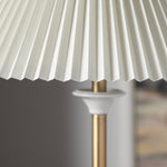 Close-up of a pleated white lampshade on a blurred background