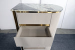 Modern side table with marble top and gold accents on a plain background