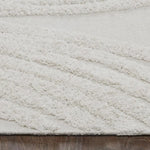 An off-white, hand woven cotton area rug with a geometric pattern and fringe edge.