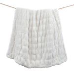 White textured blanket draped over a wooden stick on a white background