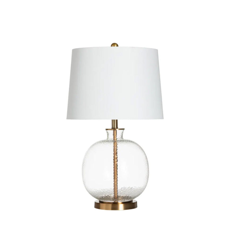 Table lamp with white shade and clear glass base on a white background