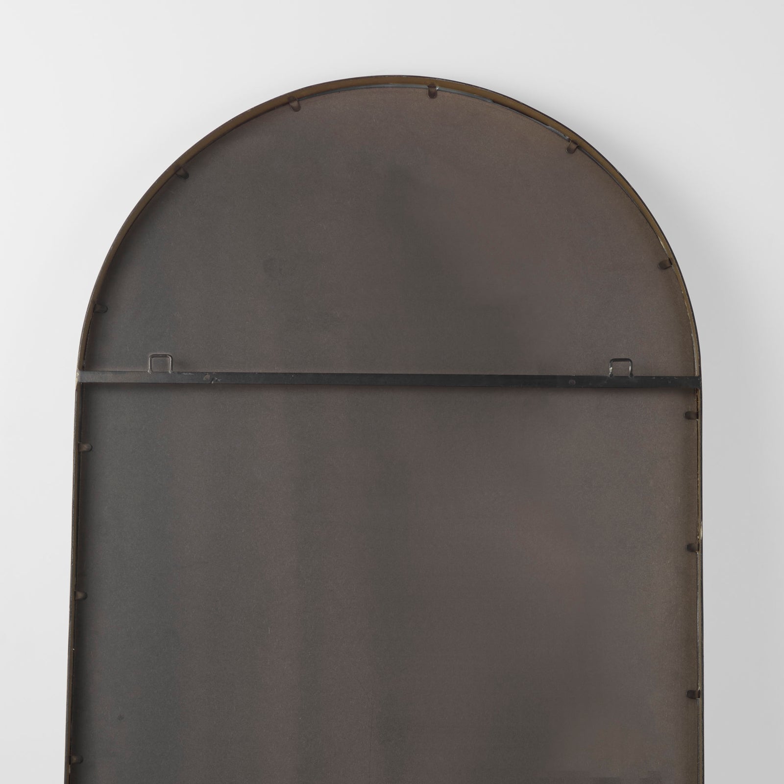 The back of a  full-length mirror with gold finished on a white background