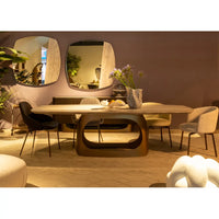 Modern dining room with a wooden table and chairs, featuring decorative elements.