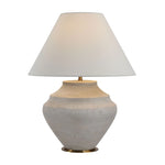 Table lamp with a textured ceramic base and a white lampshade on a white background
