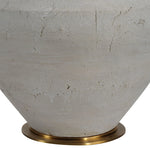 Close-up of a textured ceramic vase with a brass base on a white background