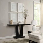 Modern living room with a black console table, white armchair, and framed abstract art on the wall.