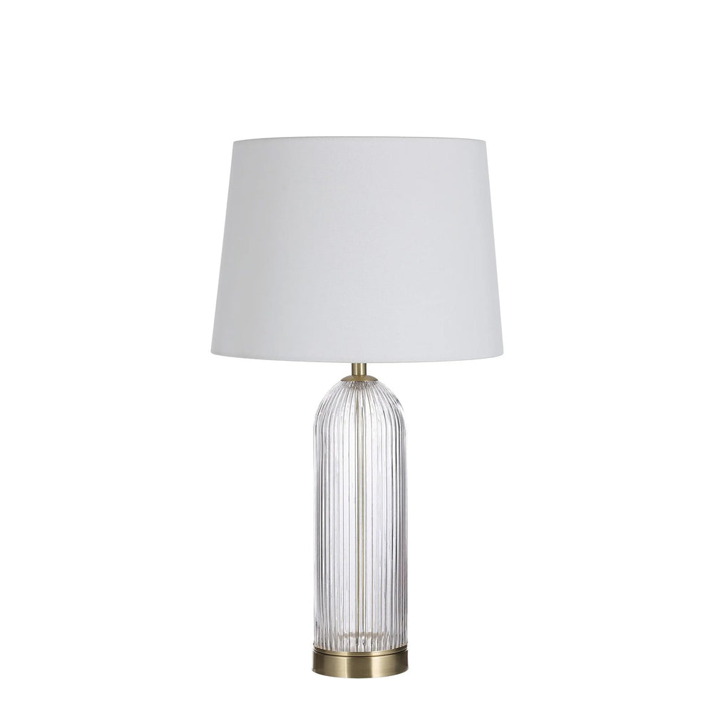 Table lamp with white shade and glass base on a white background