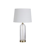 Table lamp with white shade and glass base on a white background