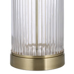 Decorative lamp with brass base and ribbed glass shade on a white background