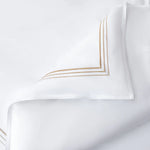 White pillowcases with gold embroidery on a white background