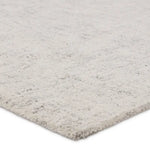 Close-up of a textured gray rug corner on a white background