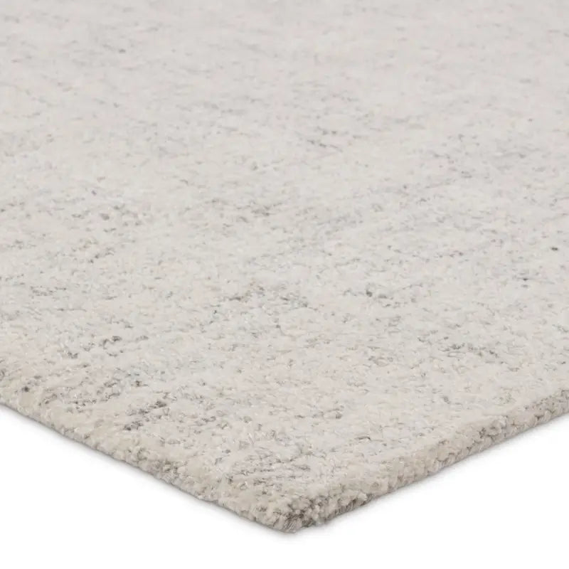 Close-up of a textured gray rug corner on a white background