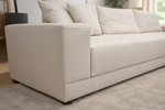 Beige sofa with cushions in a living room setting