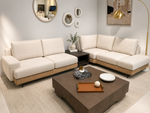 Modern living room with a beige sectional sofa, coffee table, and decorative items.