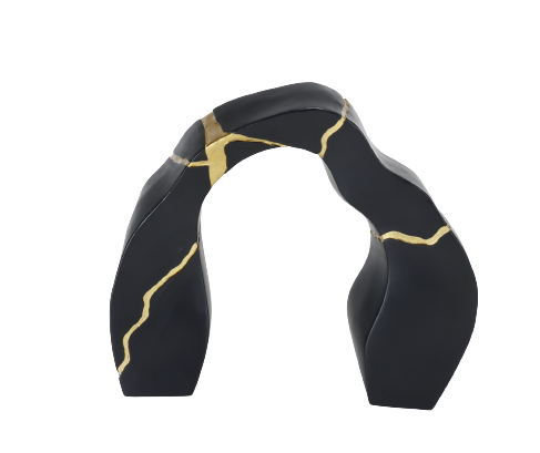 A black and gold statue decor object with a textured surface and a broken gold statue piece attached to the main body.