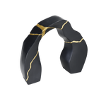 A black and gold statue decor object with a textured surface and a broken gold statue piece attached to the main body.