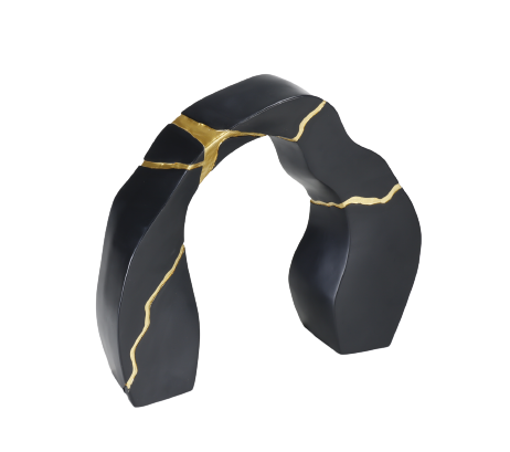 A black and gold statue decor object with a textured surface and a broken gold statue piece attached to the main body.
