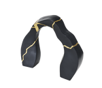 A black and gold statue decor object with a textured surface and a broken gold statue piece attached to the main body.