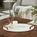 Decorative tray with candle and diffuser on a wooden table in a living room setting
