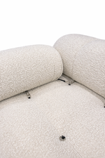 Close-up of a textured beige sofa with visible screws on a white background