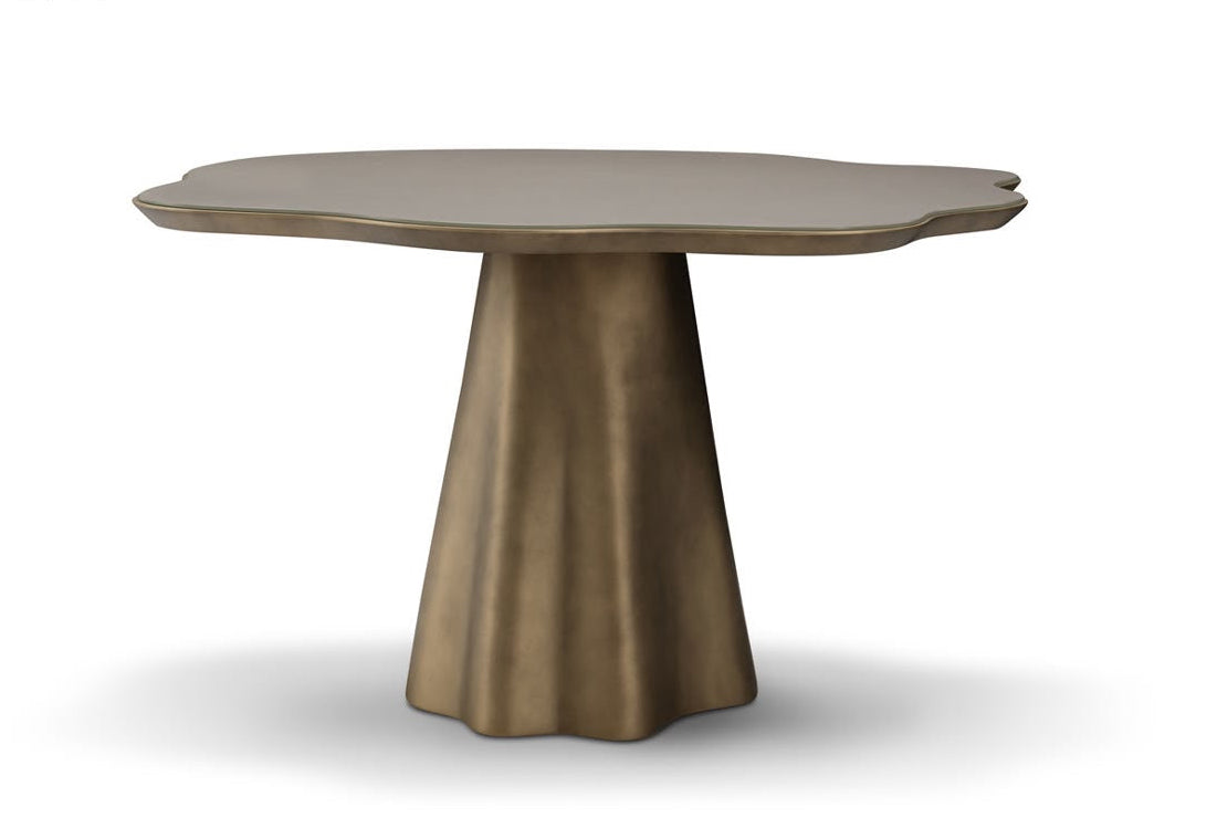 A modern sculptural dining table featuring a wide, organic-shaped top in a warm taupe-brown finish and a flared, tapered pedestal base in a metallic bronze tone, shown on a white background with a soft shadow.