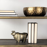 A decorative brass bull figurine with a rustic-gold polish finish.