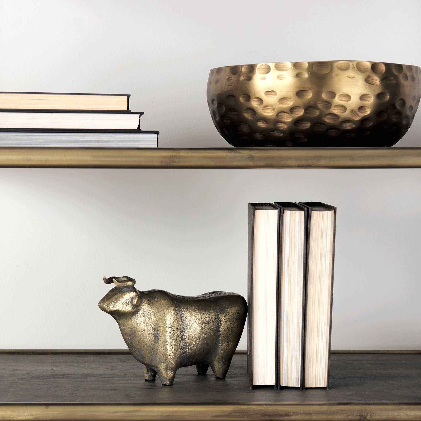 A decorative brass bull figurine with a rustic-gold polish finish.