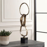 Decorative sculpture on a table with a plant in the background