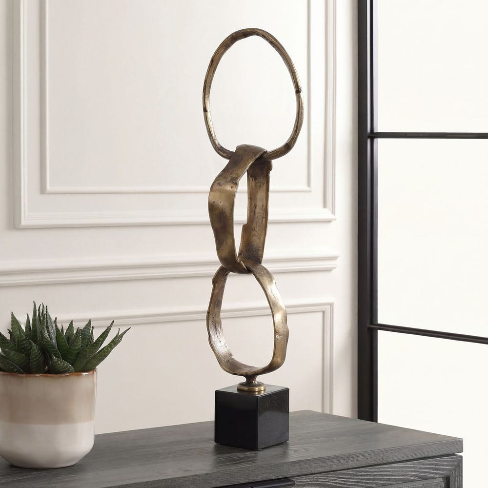 Decorative sculpture on a table with a plant in the background