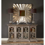 Decorative sideboard with a large mirror above it against a dark wall.