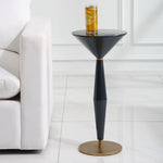 Black and gold side table with a glass of iced tea on a white floor.