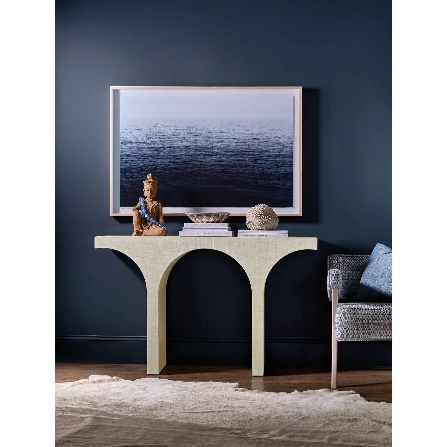 Modern console table with decorative items against a dark blue wall