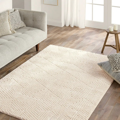 Living room with a textured beige rug, gray sofa, and wooden floor.