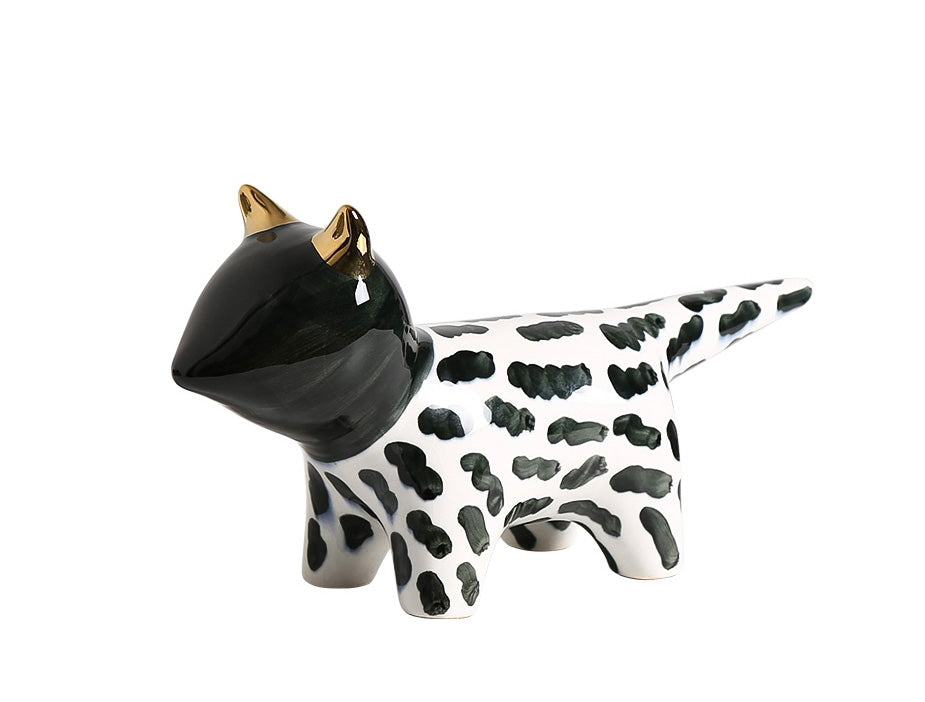 Black and white cow-shaped object with gold horns on a white background
