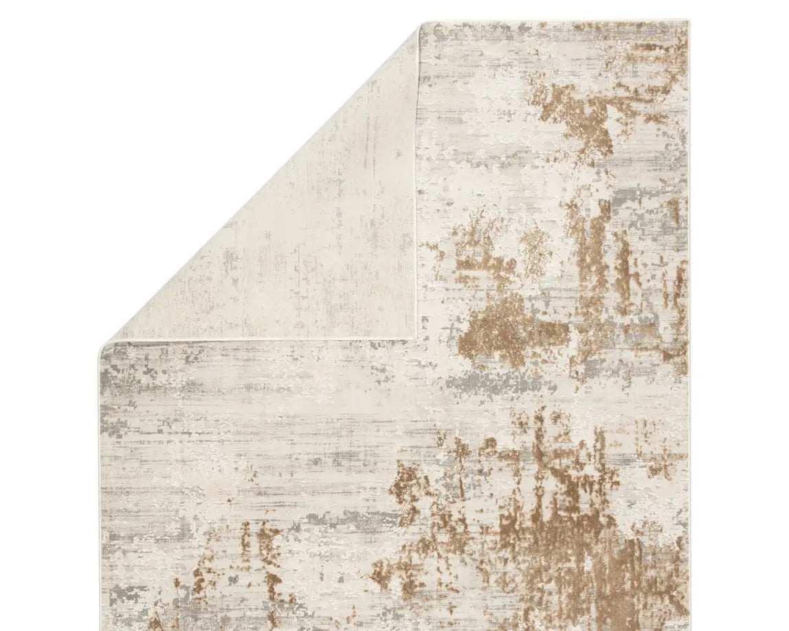 A power loomed area rug with a distressed texture design in beige and brown tones.