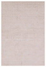 A beige area rug with a textured surface, power loomed construction, and a visible brand tag.