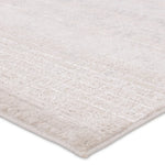 A beige area rug with a textured surface, power loomed construction, and a visible brand tag.