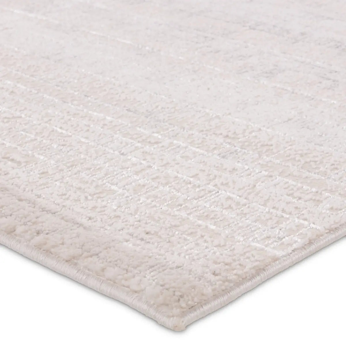 A beige area rug with a textured surface, power loomed construction, and a visible brand tag.