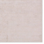 A beige area rug with a textured surface, power loomed construction, and a visible brand tag.