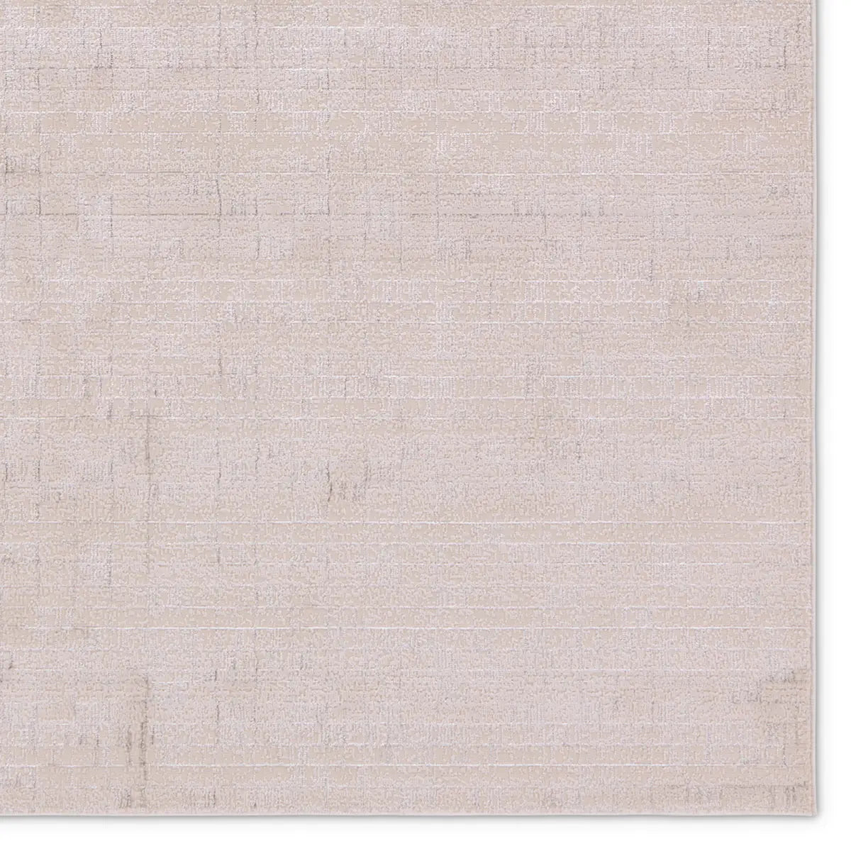 A beige area rug with a textured surface, power loomed construction, and a visible brand tag.