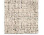A beige wool area rug with a textured weave pattern.