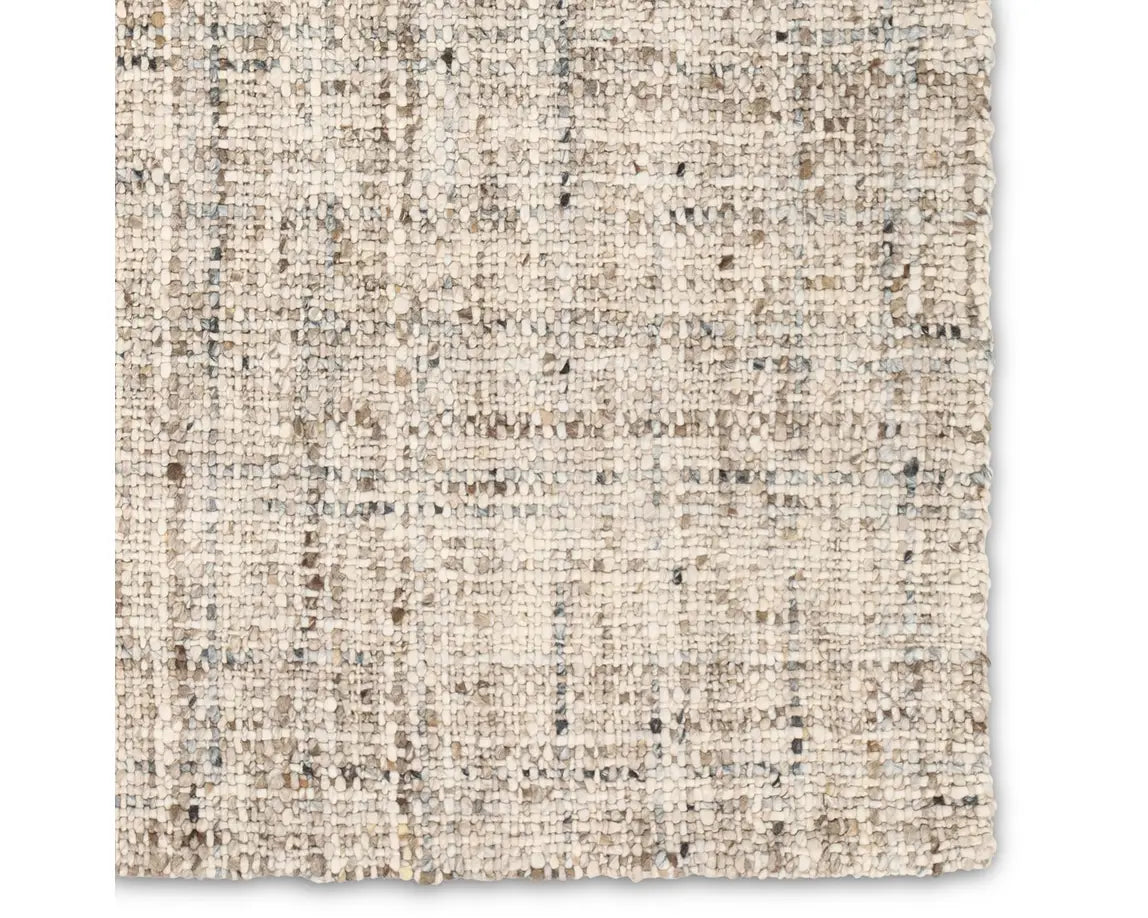 A beige wool area rug with a textured weave pattern.