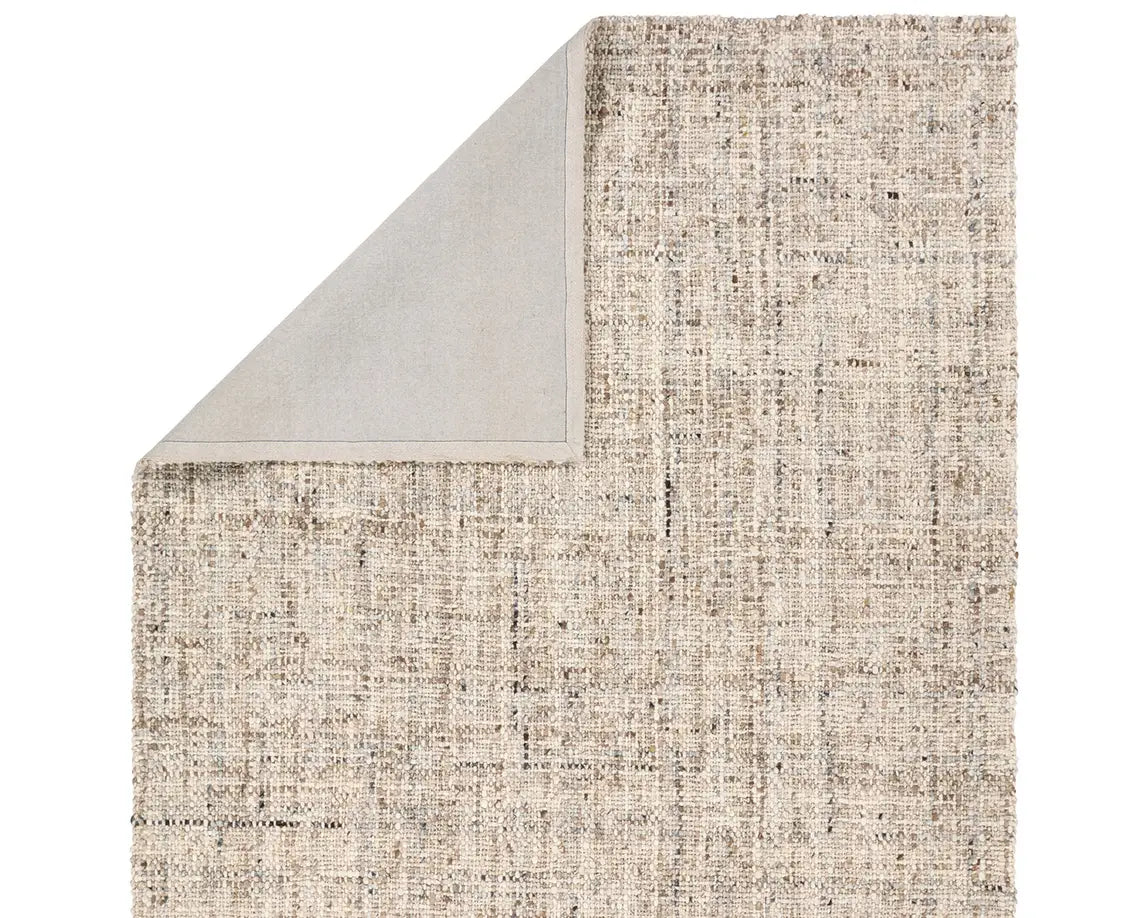 A beige wool area rug with a textured weave pattern.